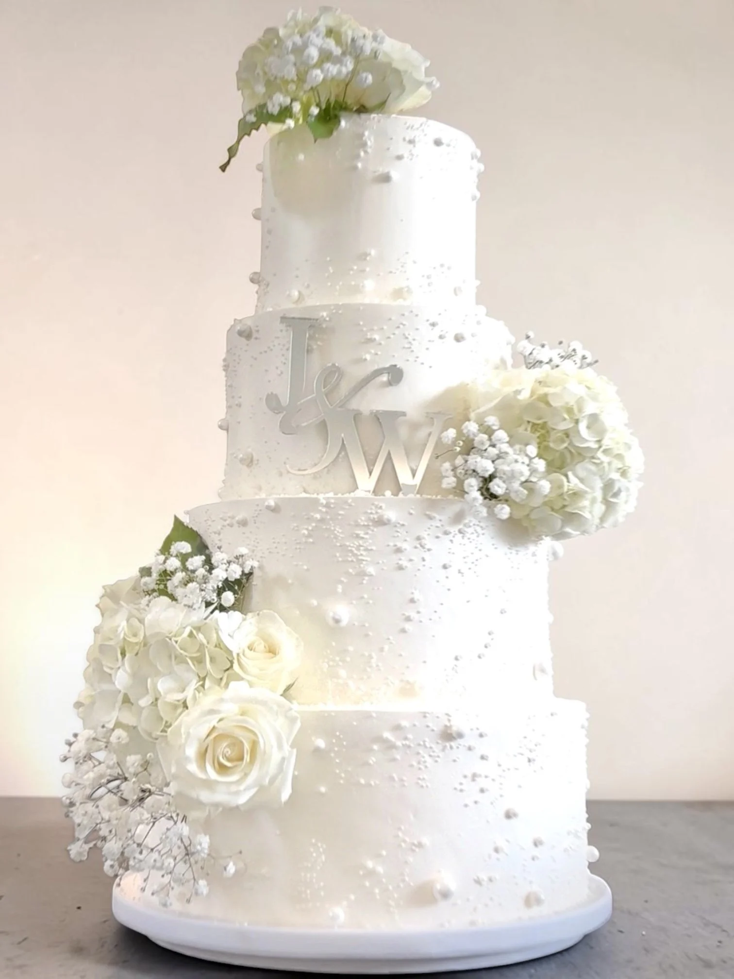 Custom 4 tier Wedding cake with pearl application and fresh florals.JPG
