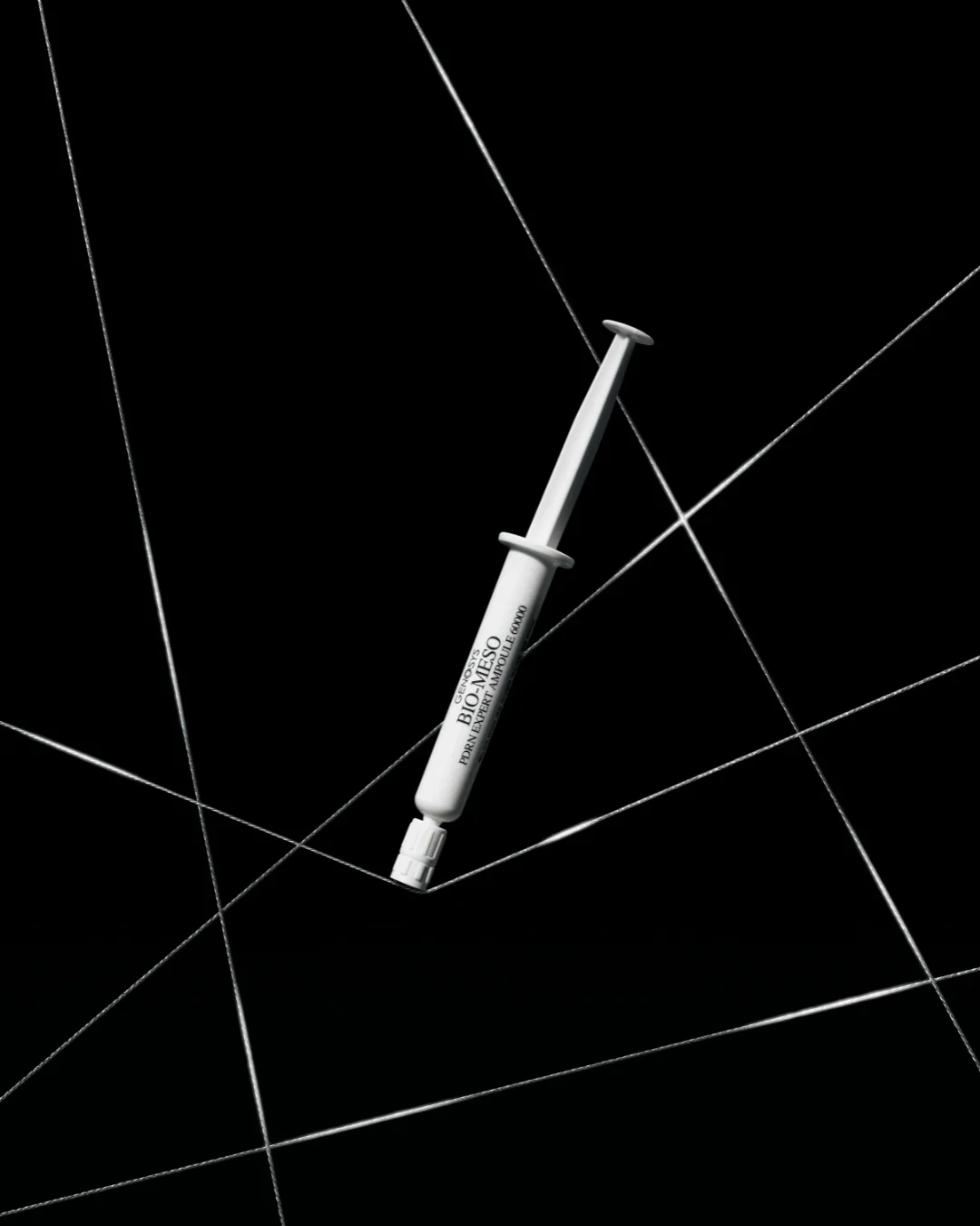 A syringe labeled 'Bio-MESQ' lying on a black surface with white geometric lines.