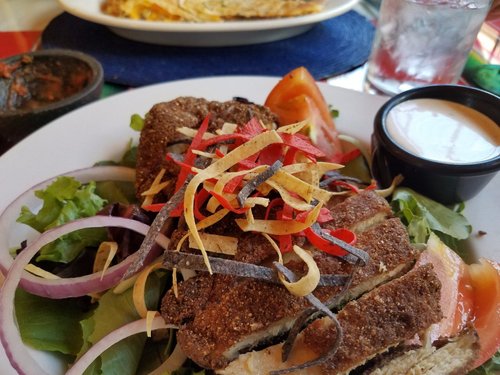 Blue corn chicken salad with crispy cornmeal-crusted chicken, tortilla strips, red onion and tomato
