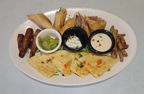Sampler platter with taquitos, quesadilla, guacamole, sour cream and cheese dip