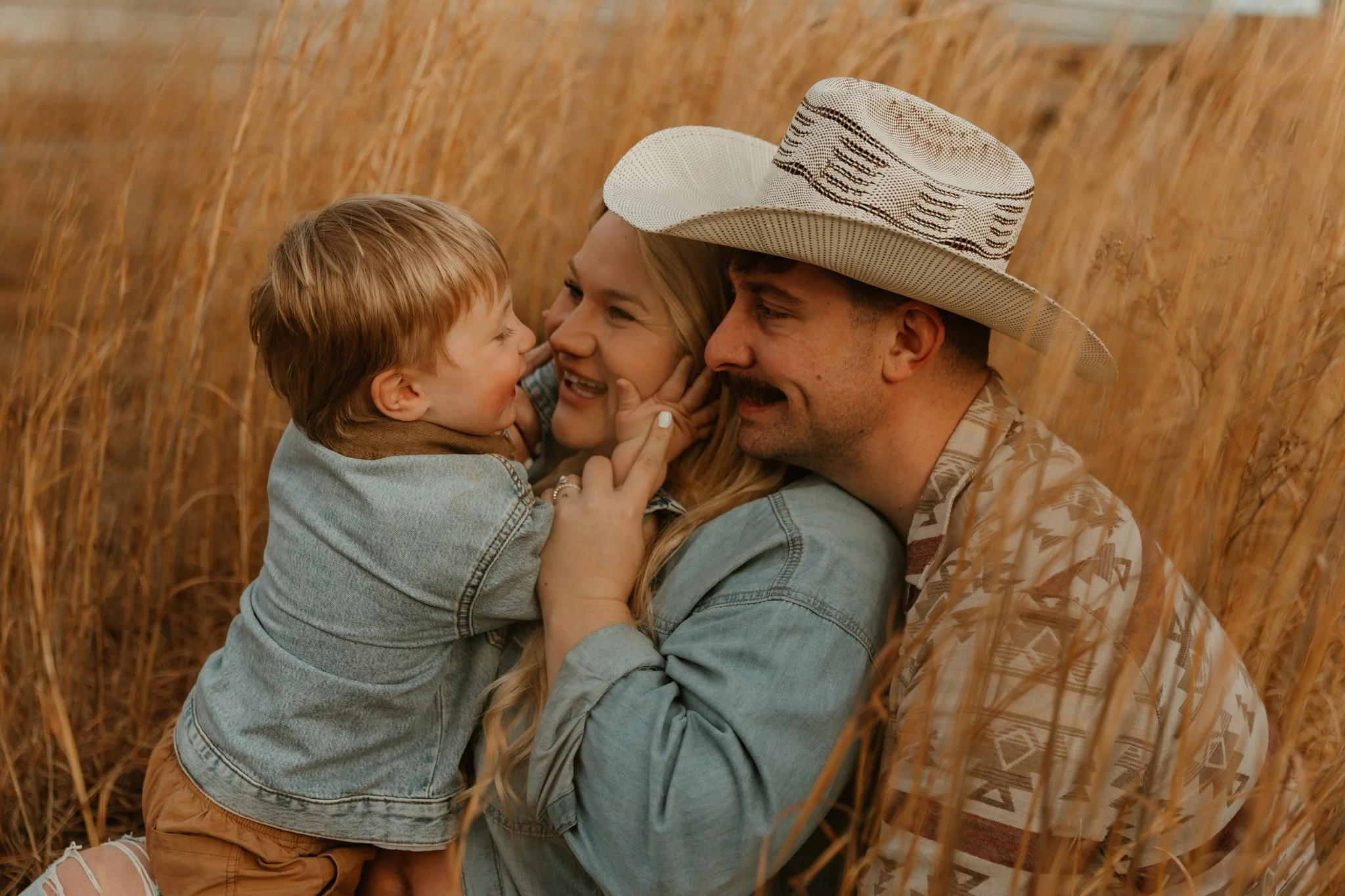 Family of five having fun and holding hands in the shallow waters of the ocean during sunset