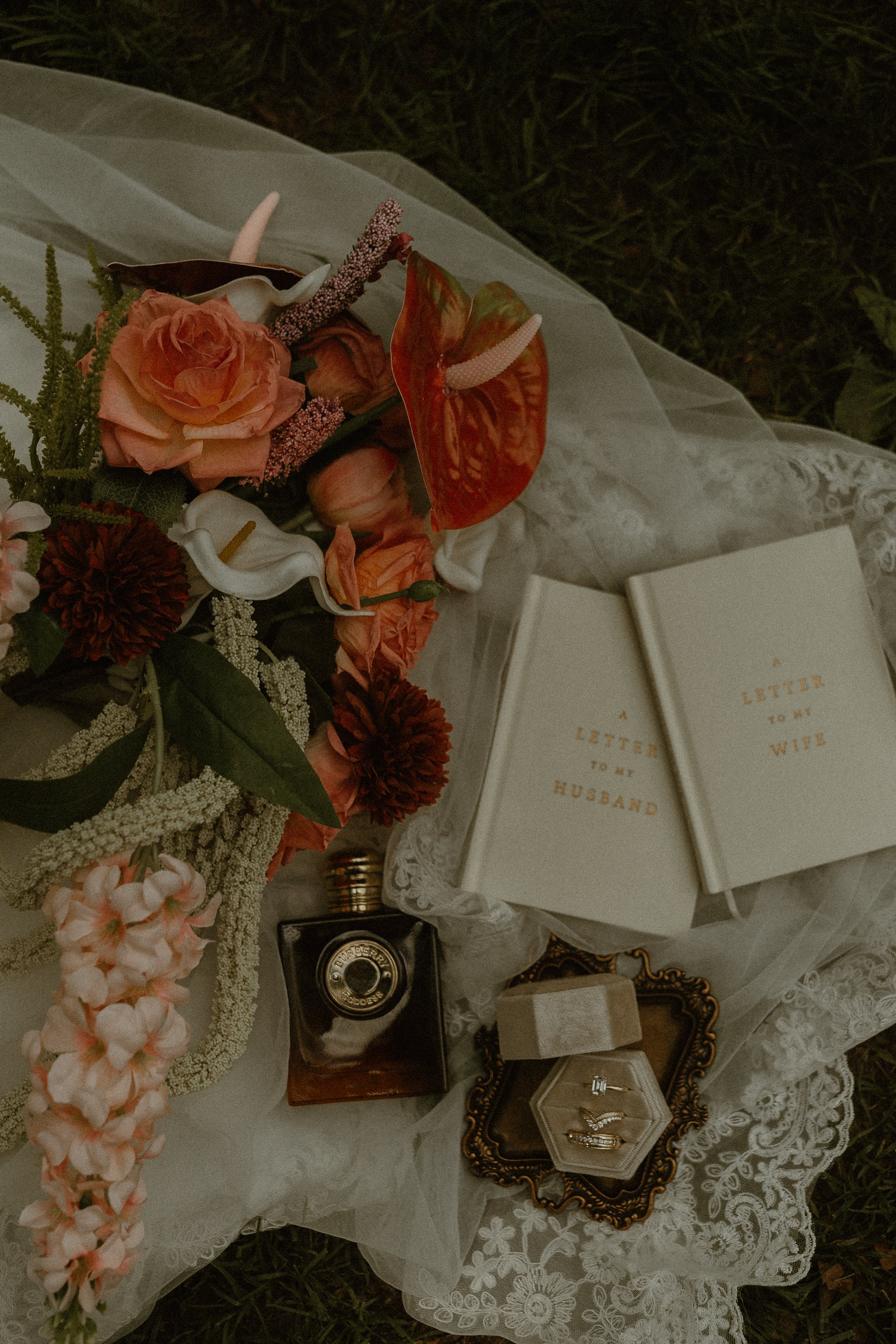 A decorated table with flowers, jewelry, and greeting cards that read 'Letter to my Husband' and 'Letter to my Wife'.