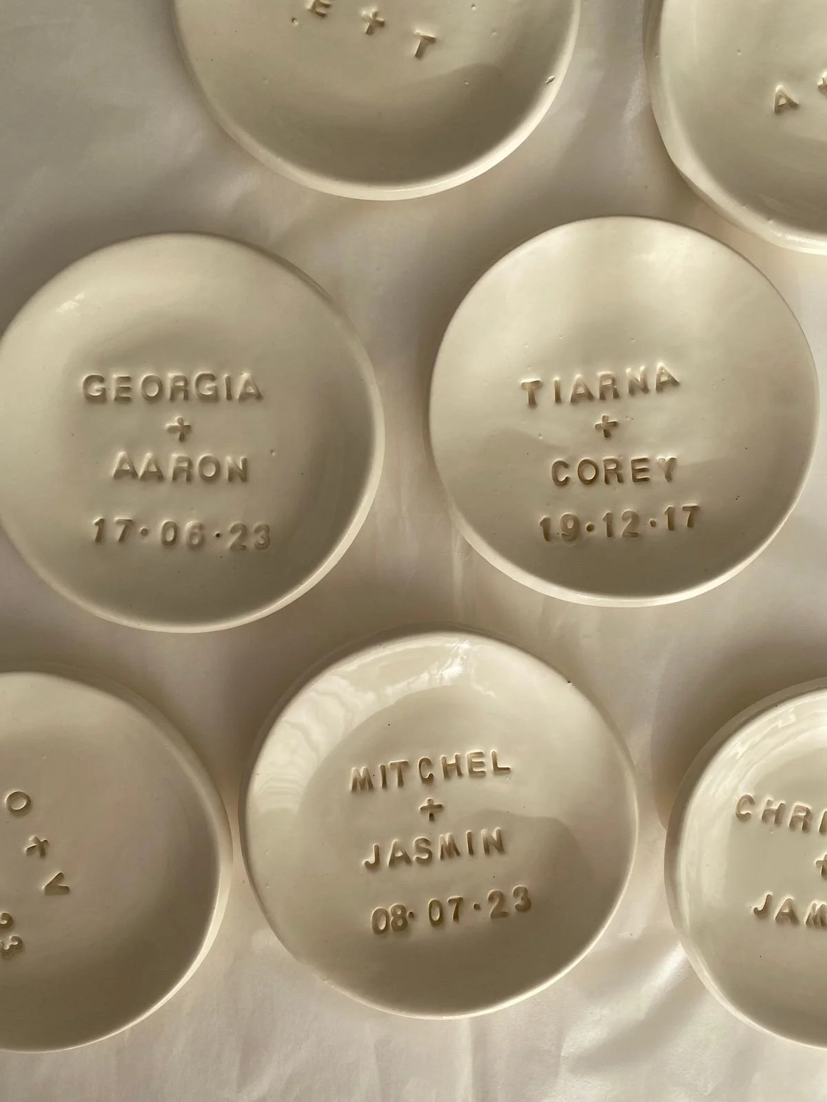 Pastilla de aluminio con inscripciones grabadas de nombres y fechas, en varias de ellas se leen nombres como Georgia, Aaron, Tianna, Corey, Mitchel, Jasmin y fechas correspondientes.
