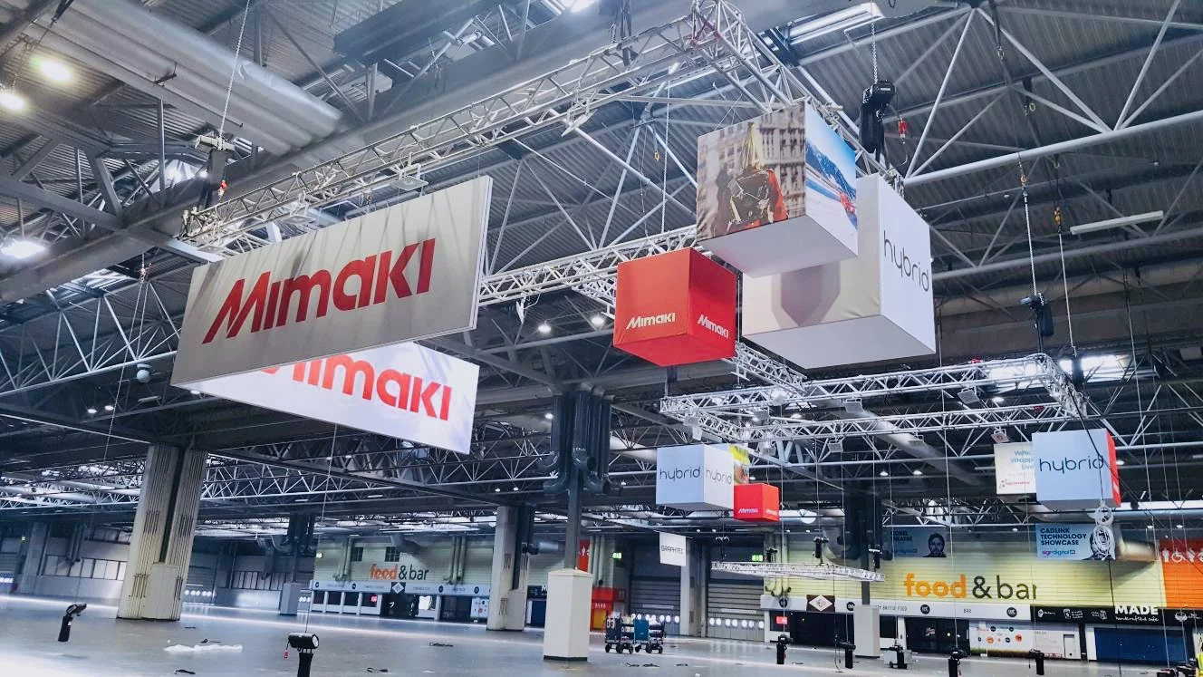 Large-format hanging banner structures produced and installed for this exhibitor, ensuring maximum visibility across the show floor.