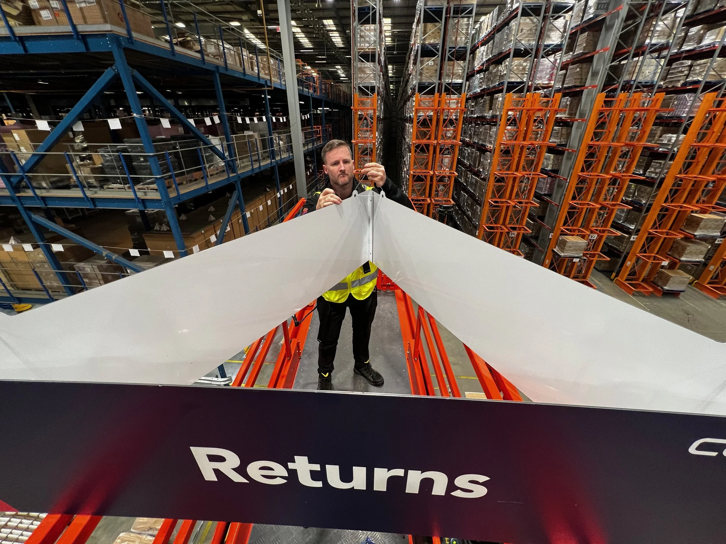 Hanging and wayfinding signage for warehouses and factories — produced and installed by the Boost team.