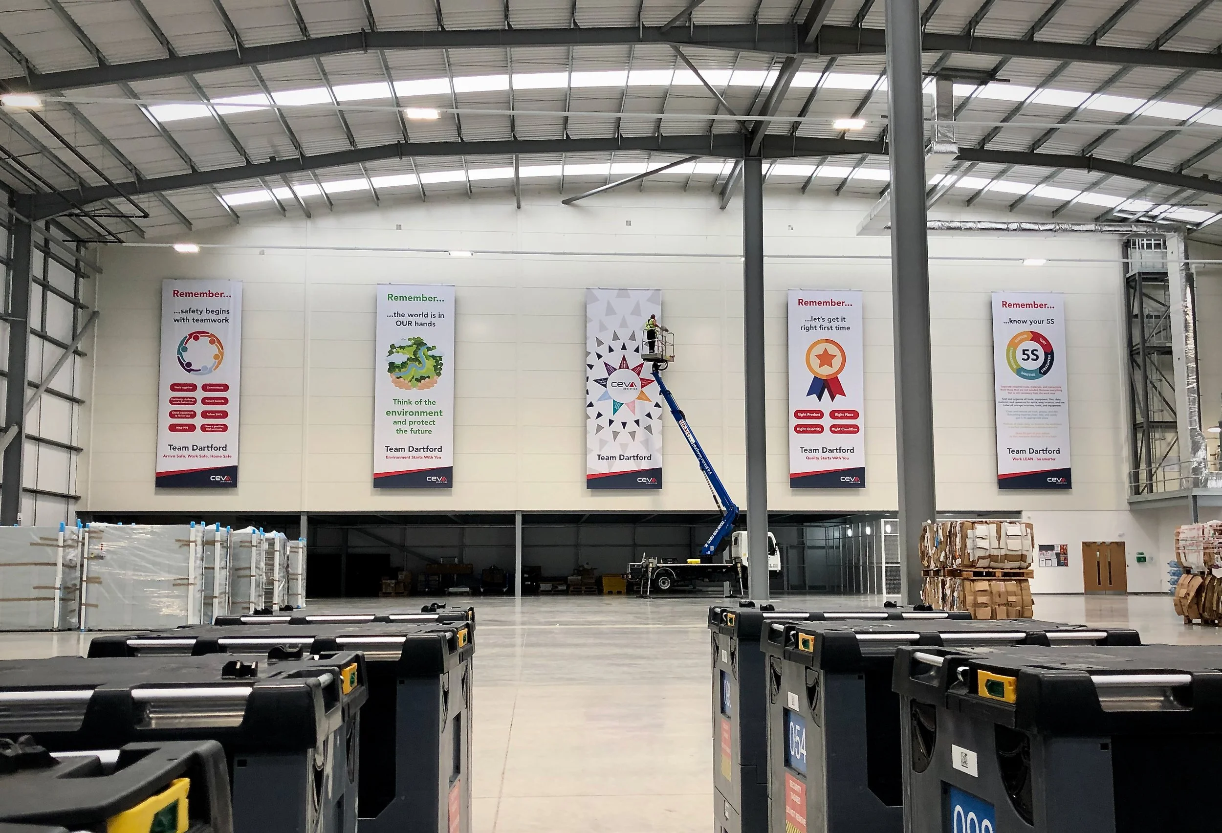 Large hanging banners installed inside this warehouse maximise visibility to create clear, high-impact messaging.