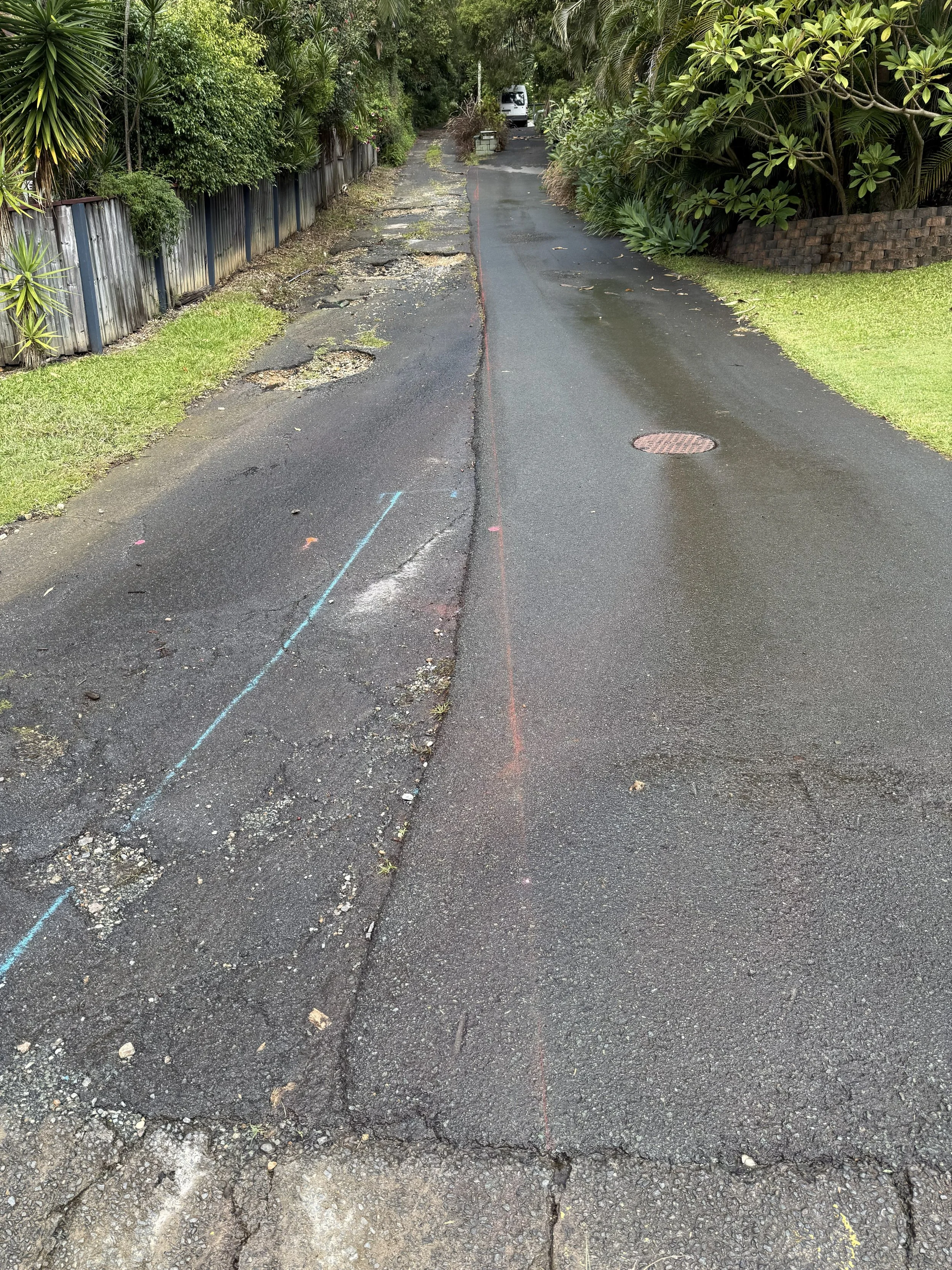 A residential street with damaged asphalt