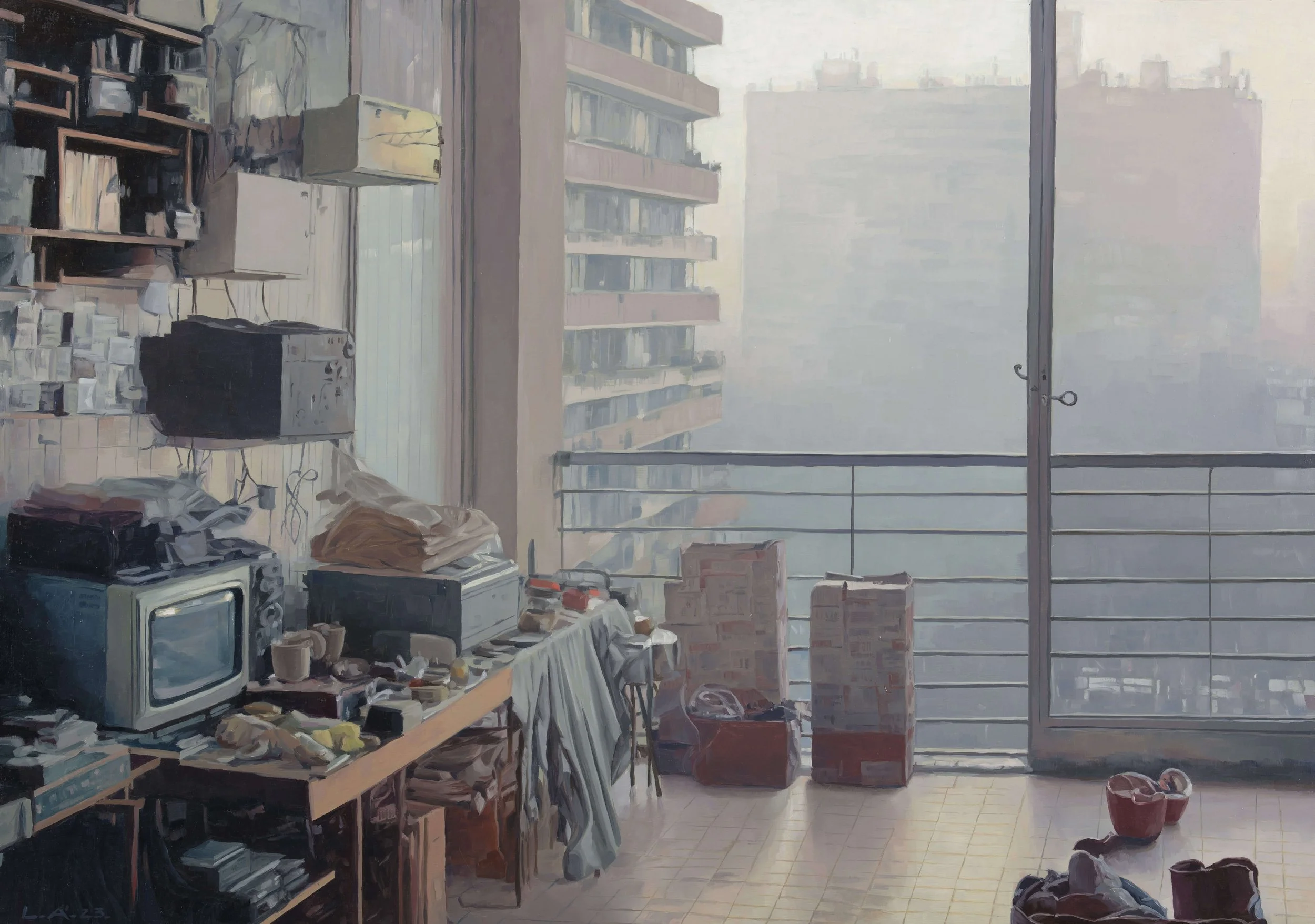 An indoor balcony or living space with clutter. A wooden table with a small old-fashioned television, books, cups, and laundry. Shelves on the wall holding various objects. Outside the balcony, tall apartment buildings are visible through sliding gla