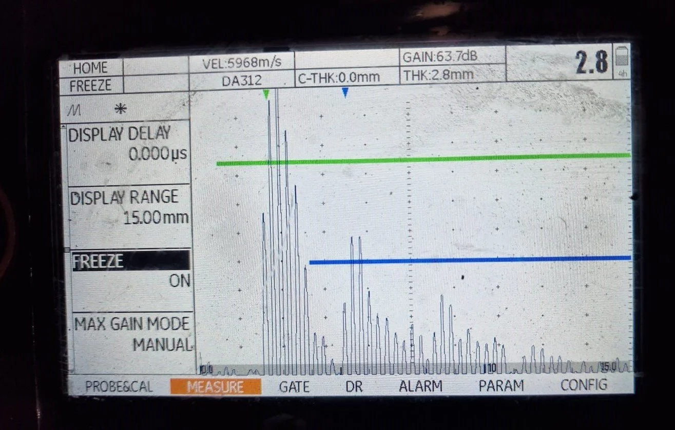 Oscilloscope screen displaying signal measurements, with signal spikes and calibration details.