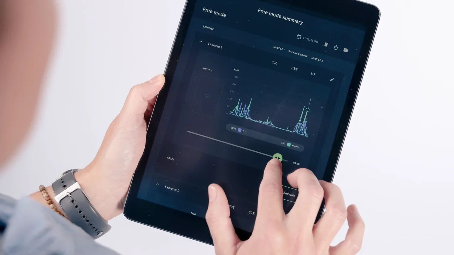 Hände am Tablet, auf dem Bildschirm die Signalkurve der Muskelaktivität