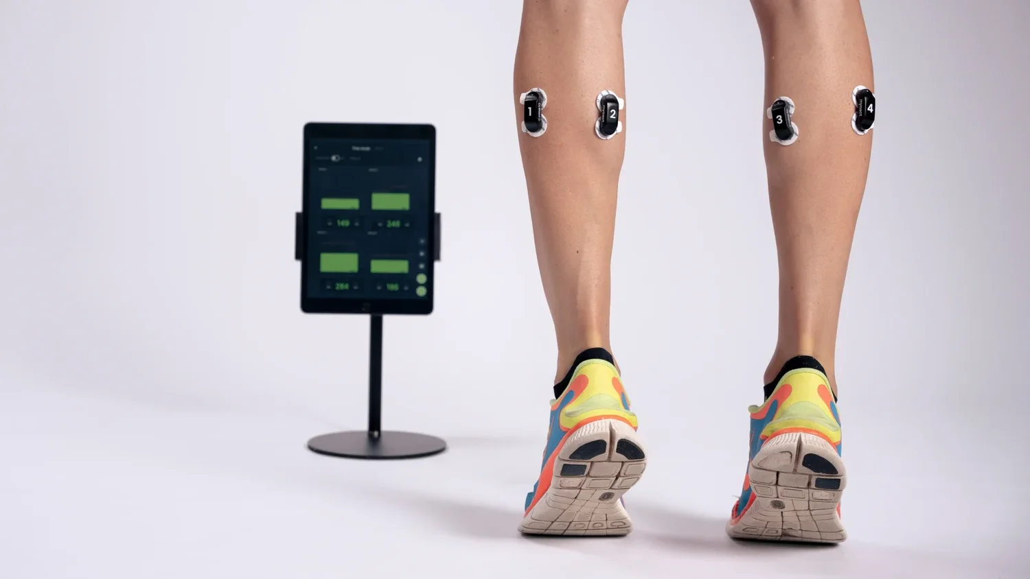 EMG-Sensoren an beiden Waden, daneben das Tablet mit der Anzeige der Muskelaktivität