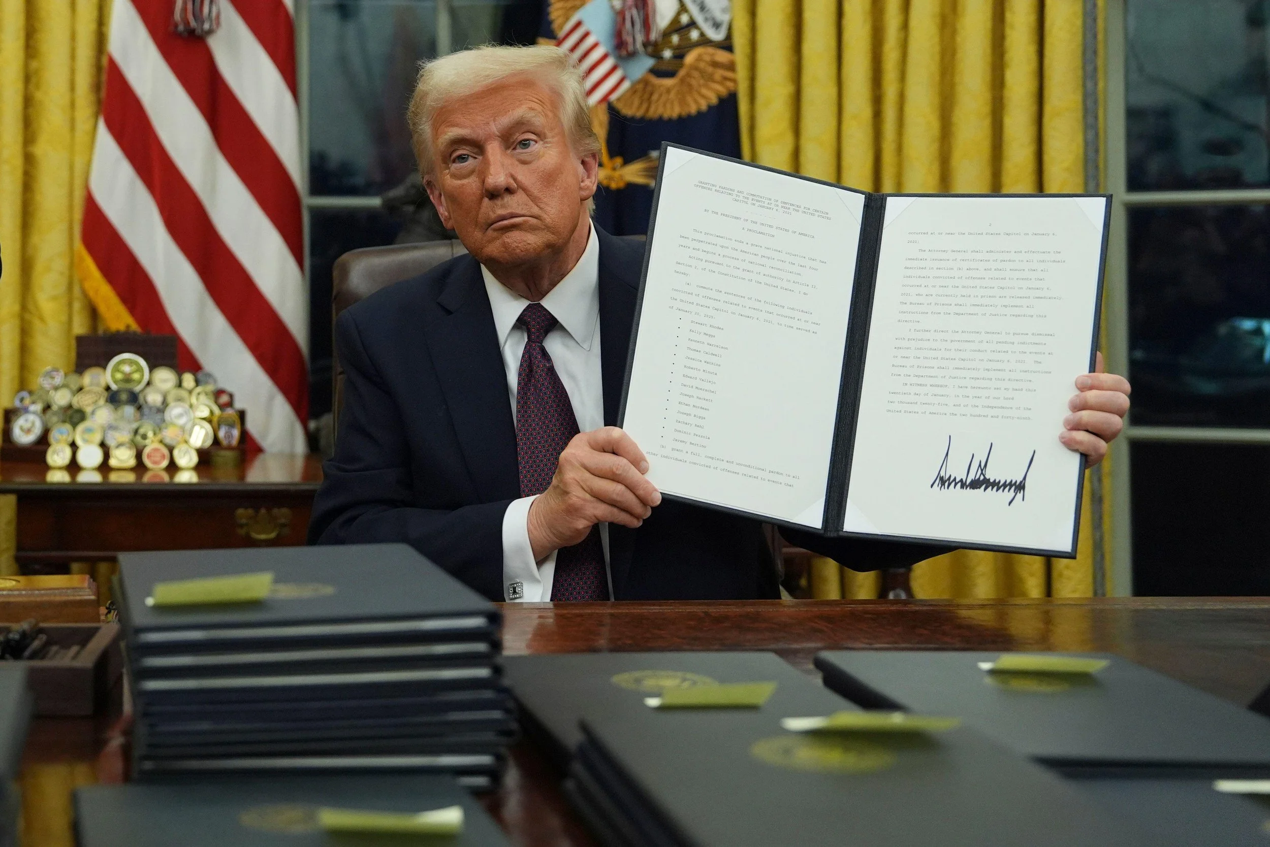 US President Donald Trump holding up a signed executive order in the White House during a news conference
