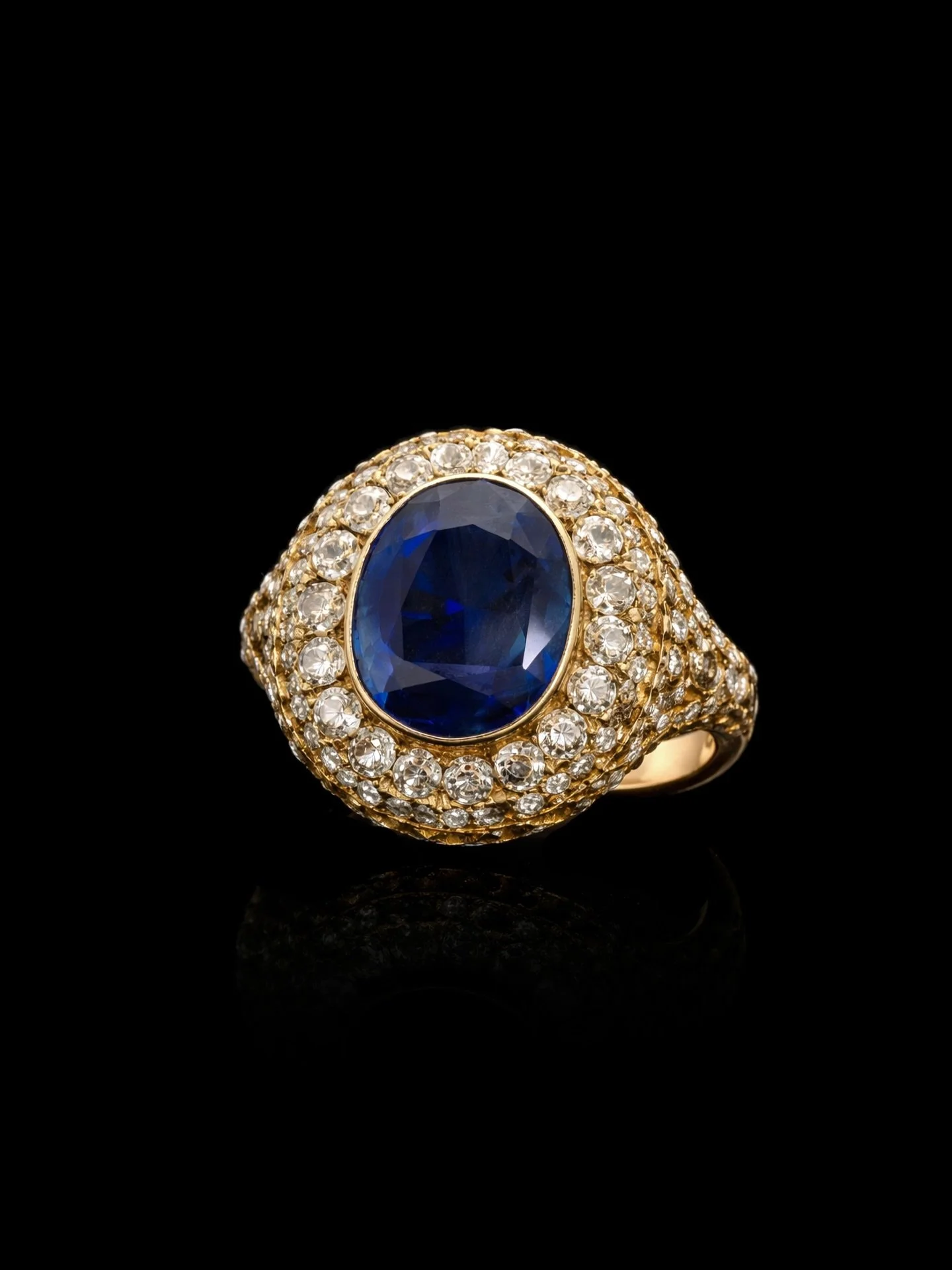 EARLY 20TH CENTURY CEYLON SAPPHIRE &amp; DIAMOND RING

Set with an oval cut intense blue Ceylon no heat sapphire weighing 6.50 carats surrounded by old cut diamonds. Diamonds are bright and lively. Mounted in 18kt yellow gold. Circa 1920. Accompanied