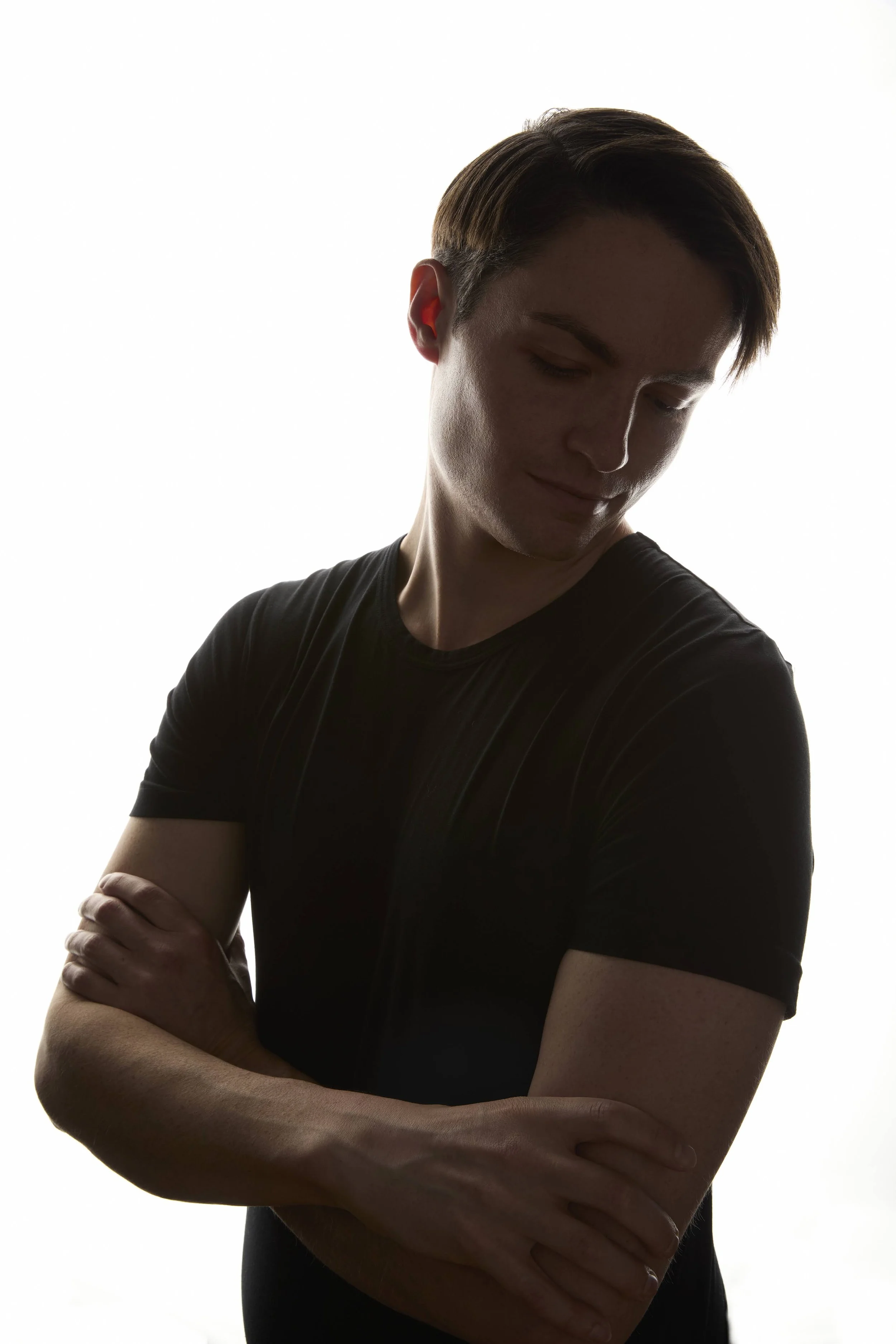 Backlit portrait of Michael D. Hughes in a black T-shirt