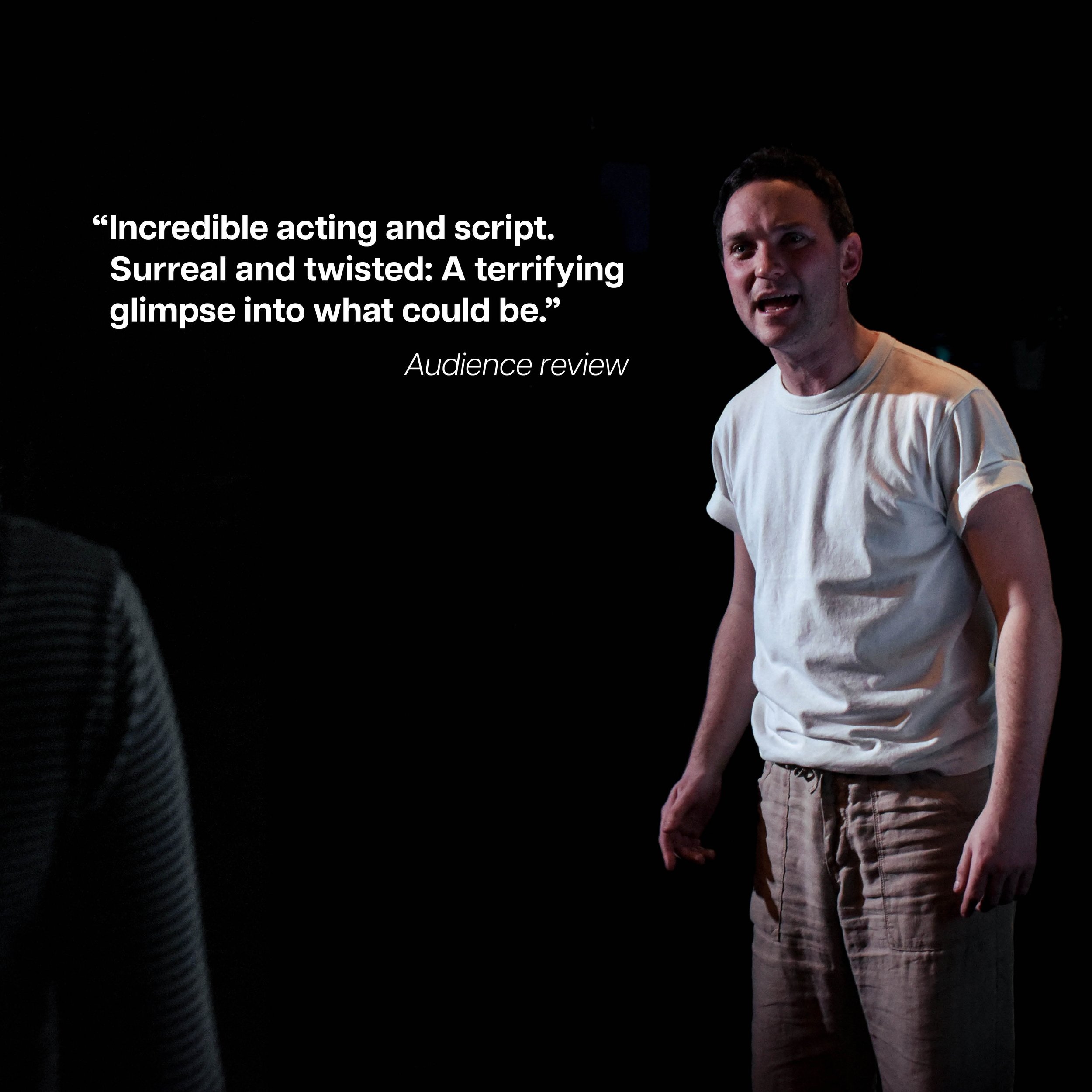 A man with short dark hair wearing a white t-shirt and beige pants, standing and speaking in front of a dark background. On the left side, white text of a review is displayed.