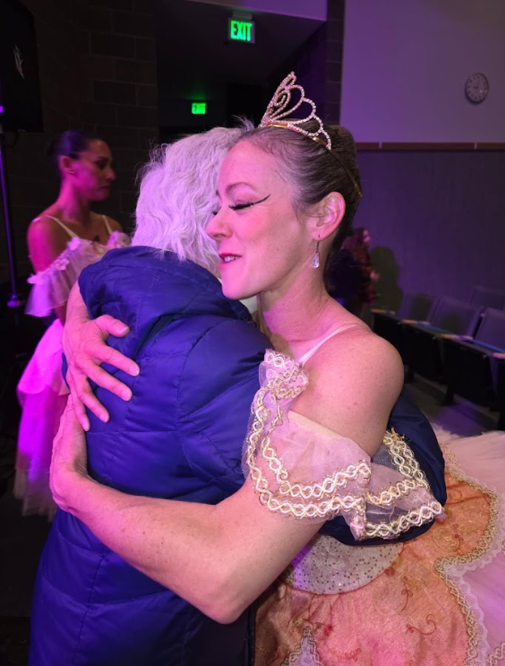 a brunette ballerina hugs a woman in a blue puffy coat