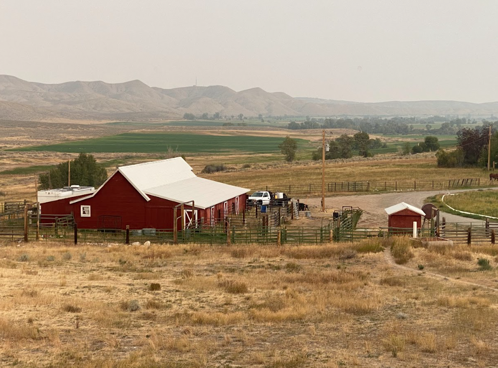red barn with smoke covered mountains in background