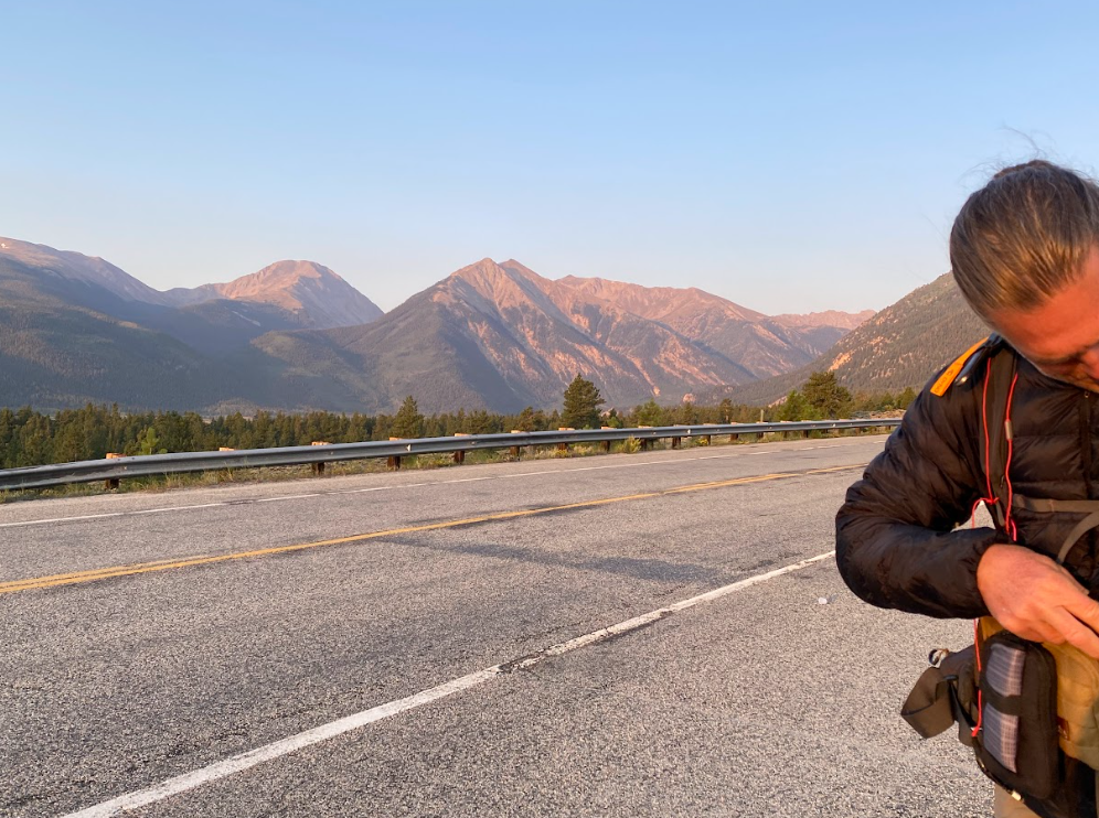 mountain view from the side of a road with a man checking his watch
