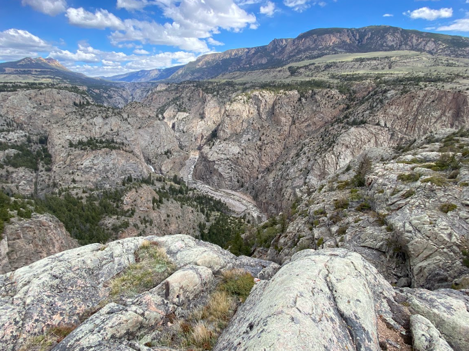 granite cliffs dominate this image but a faraway river runs through the center
