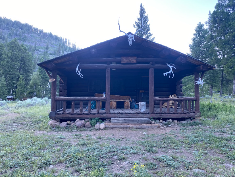 a classic log cabin with antlers hanging off the corners