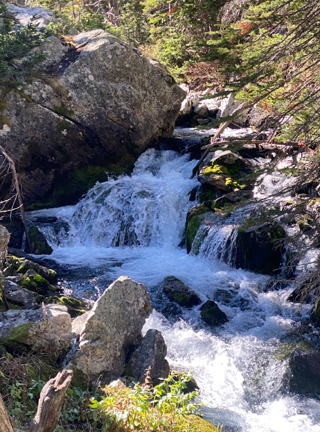 closeup of a waterfall by a boulder