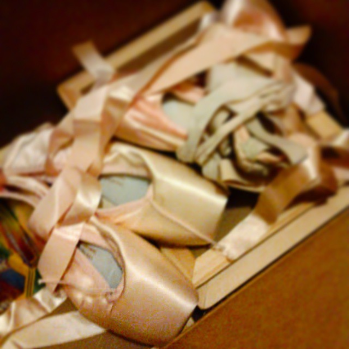 a box full of unorganized pointe shoes