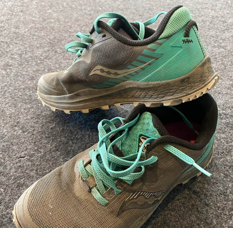 up close image of a pair of grey and teal colored shoes with Saucony brand swoosh on side