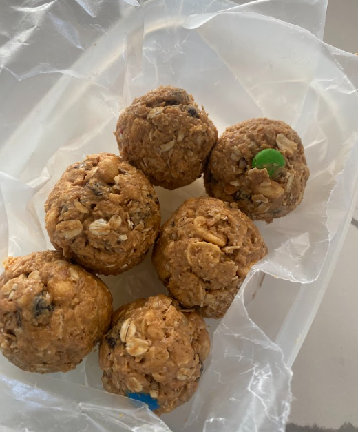 six peanut butter balls rest inside a plastic container