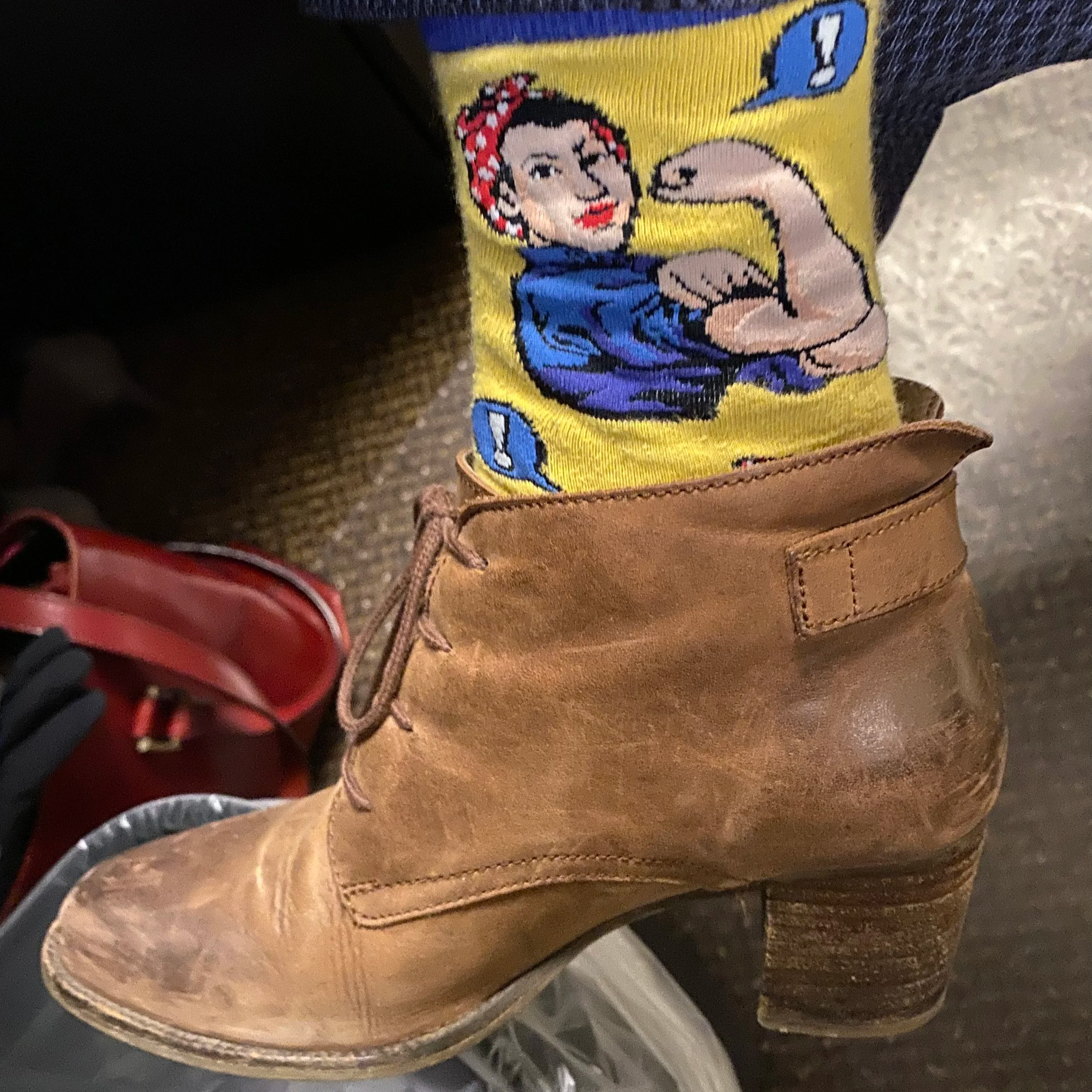 brown leather high heel shoe with sock of Rosie the Riveter peeking out