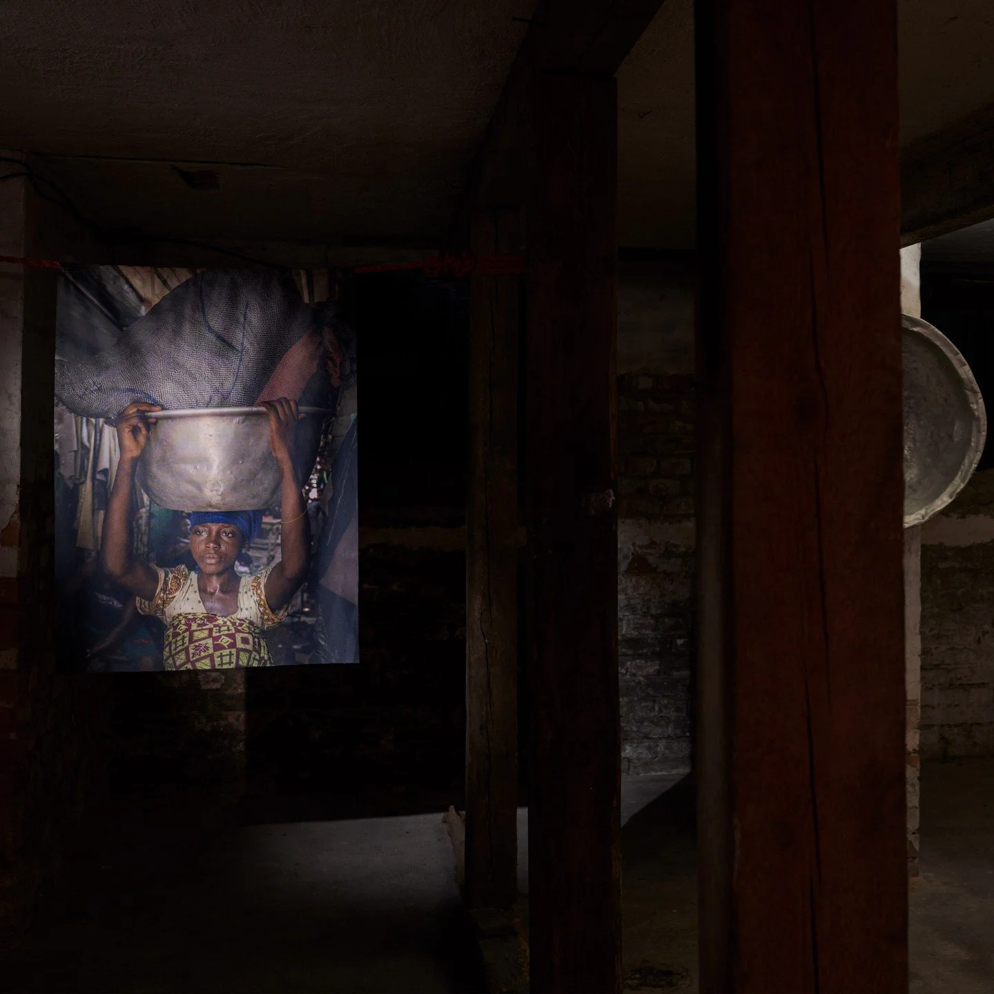 W części wystawy znajdującej się w piwnicy galerii można było obejrzeć zdjęcia kobiet &ldquo;Kayayei&rdquo; autorstwa Natalii Gormalovej i Yayry Agbofah z kolektywu THE REVIVAL. Zejście widz&oacute;w do podziemi miało wymiar symboliczny, podkreślając