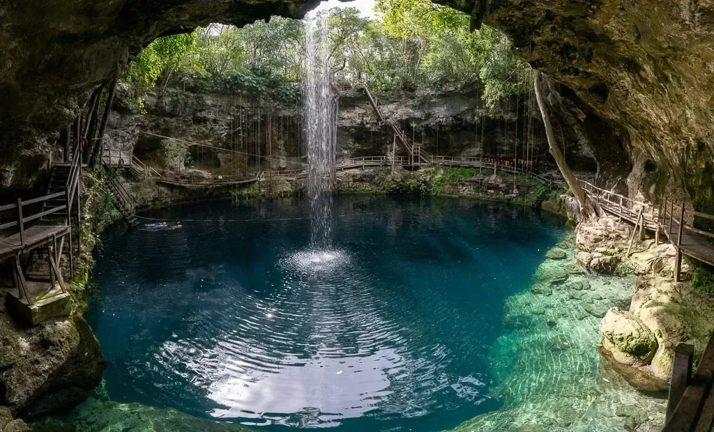 Scenic cenote near Puerto Morelos with turquoise water and lush tropical vegetation