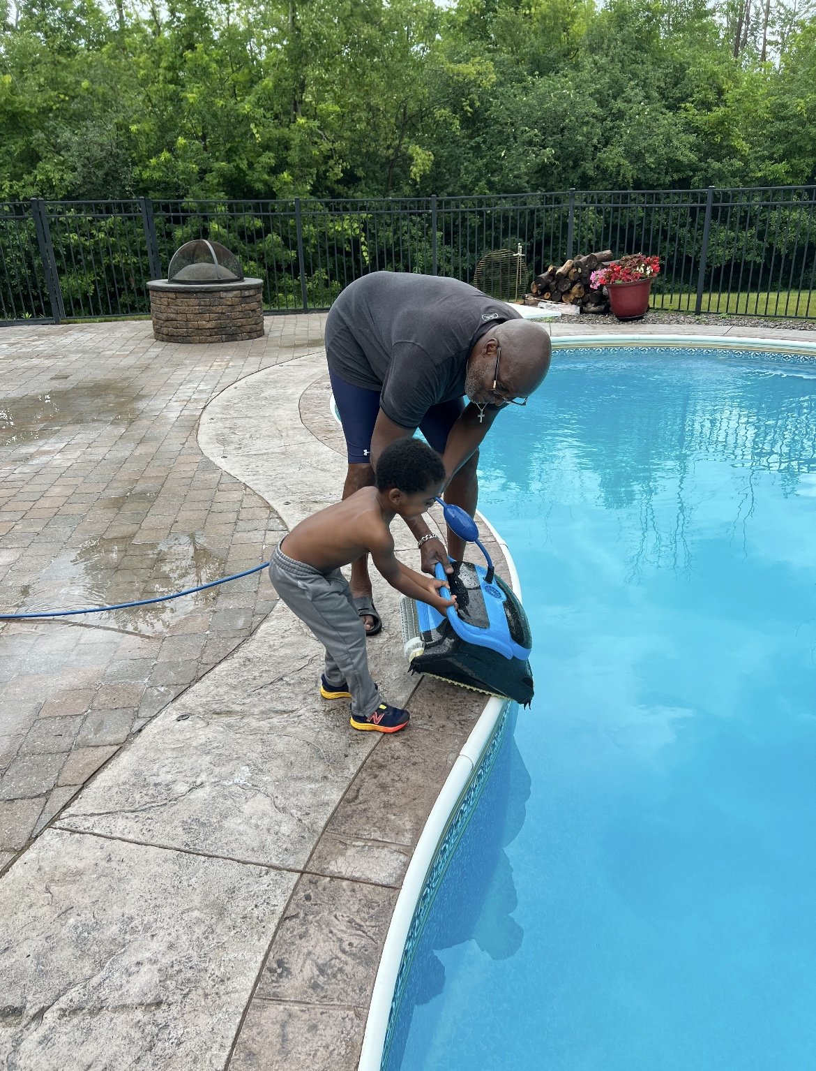 Helping grandpa use the robot to clean his pool 