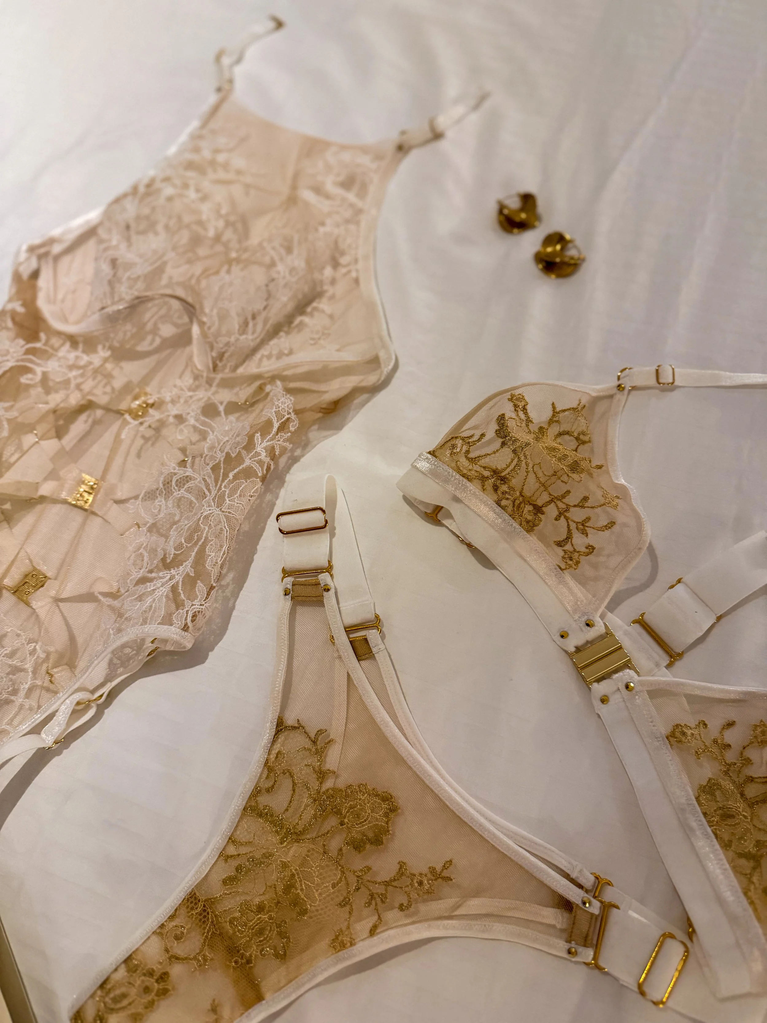 Curated luxury lingerie Milwaukee — white lace bodysuit and gold lace bra and thong at MICHAL Third Ward.