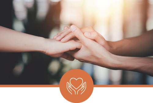 Two people holding hands in an emotional gesture with a warm background and an icon of a heart held by two hands at the bottom.