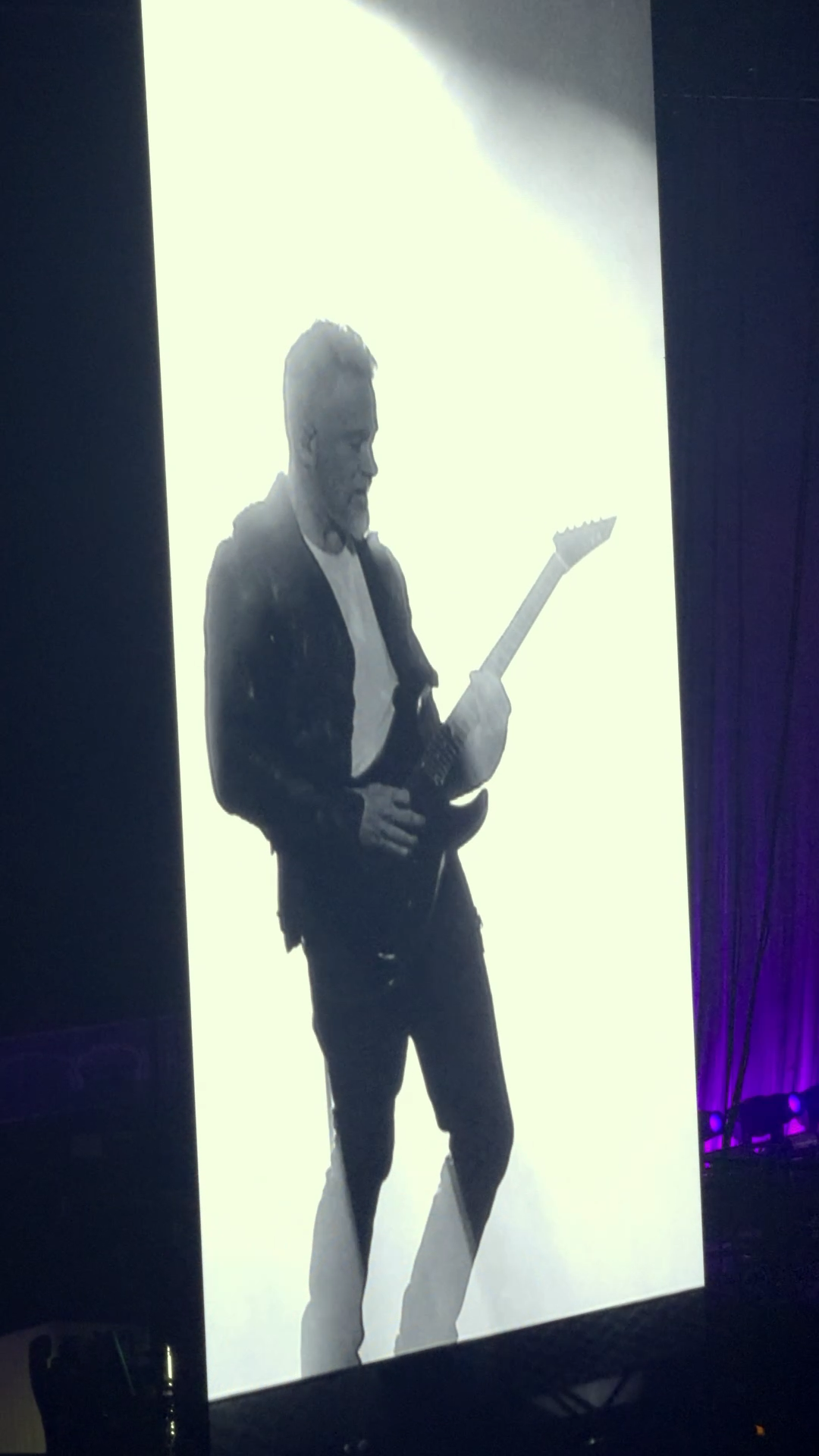 Schwarz-weiße Illustration eines Mannes, der Gitarre spielt, vor hellem Hintergrund.