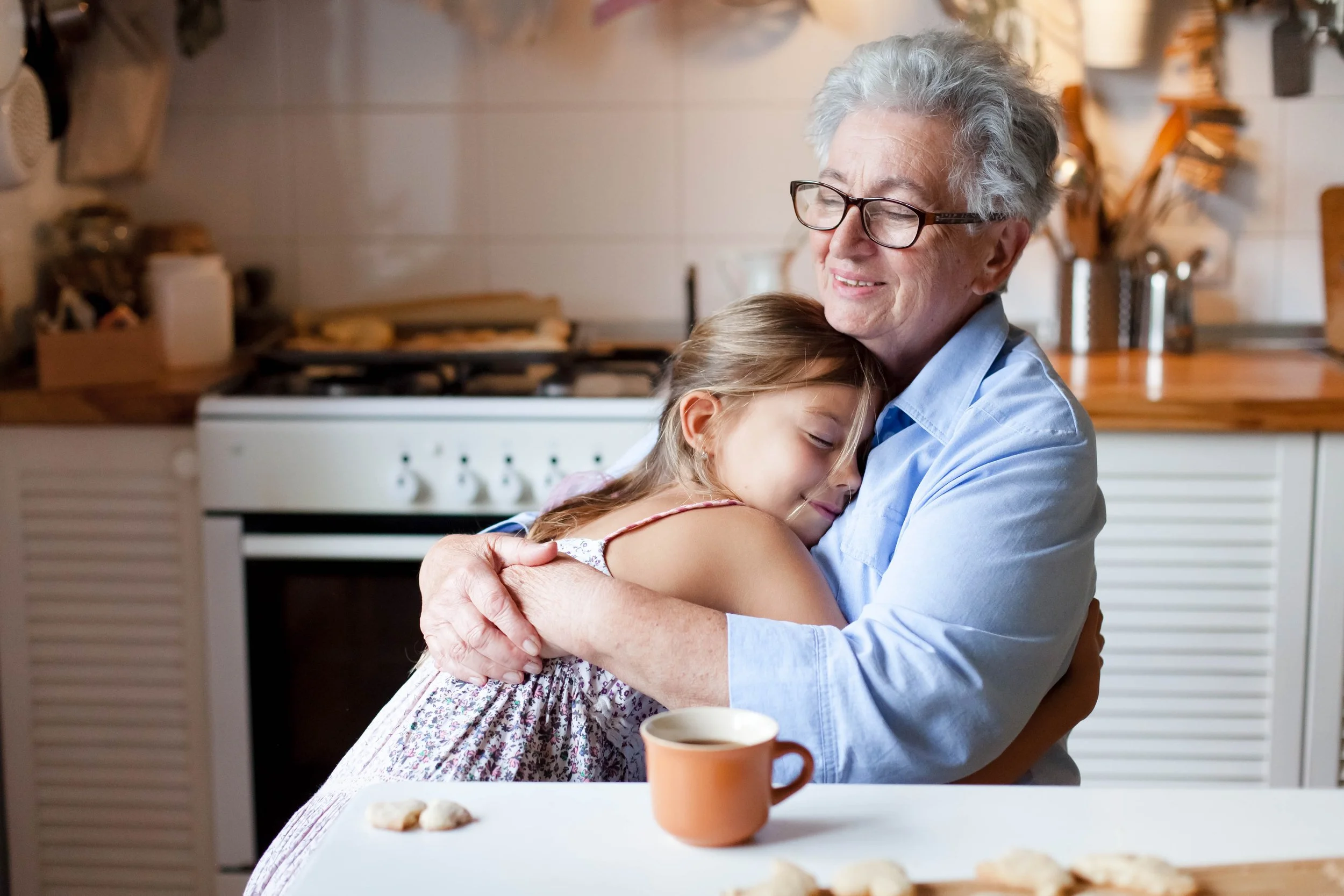 grandmother-and-granddaughter-hugging-in-kitchen