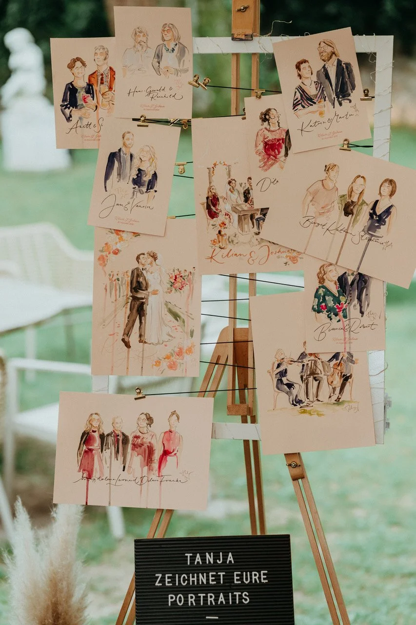 Bilderrahmen an den viele kleine Aquarellportraits geklemmt sind