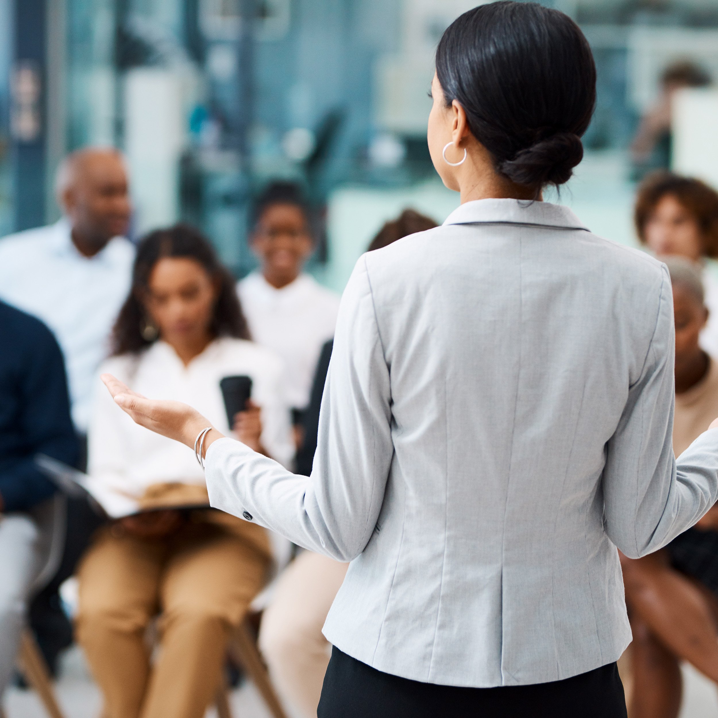 Leader engaging a room of participants during a facilitation workshop focused on team-building, listening sessions, and strengths-based organizational development.
