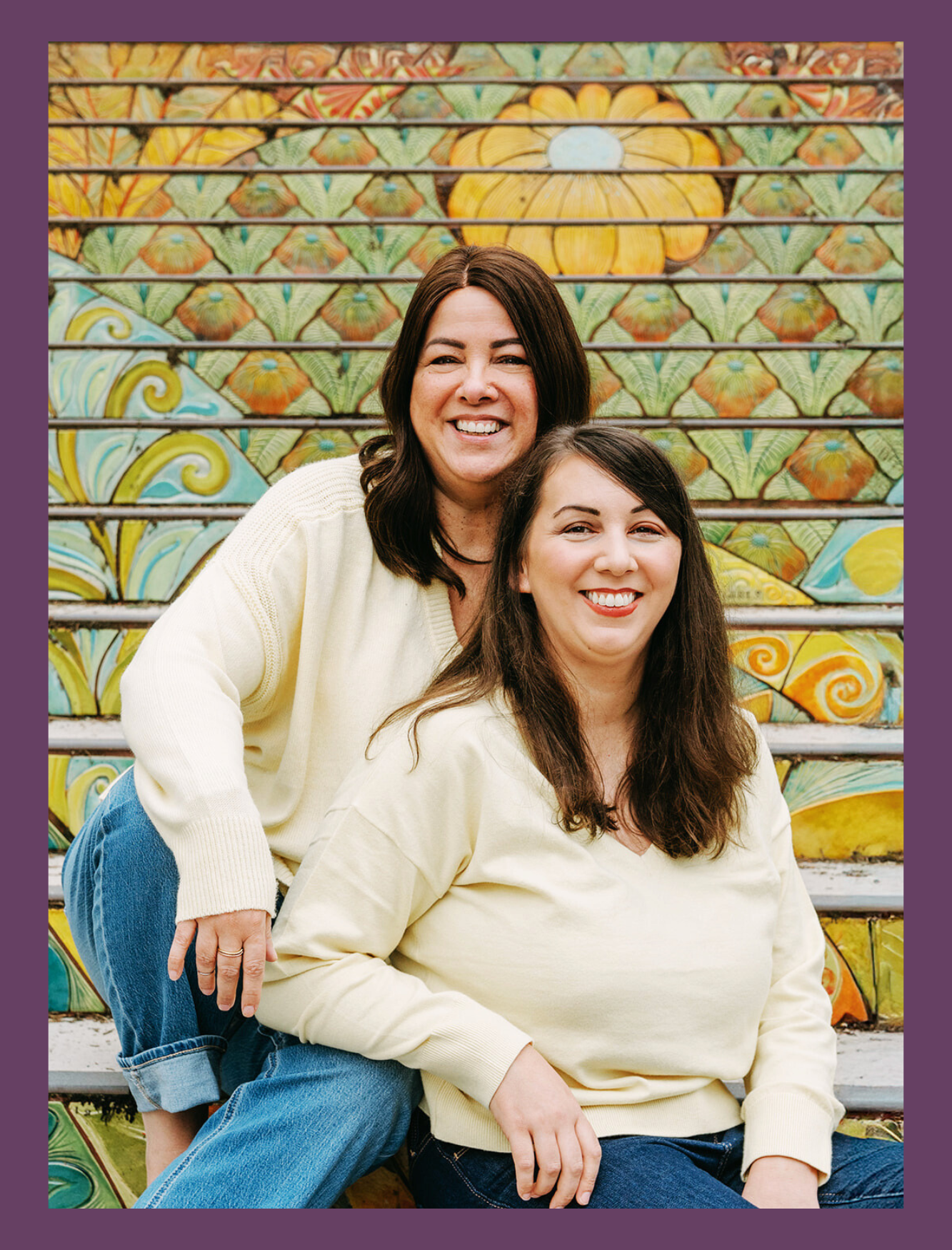 Virtual Assistants Trish and Kate sitting on colorful stairs. Working together to photographer manage systems. Photo taken by the amazing https://www.photoposy.com/