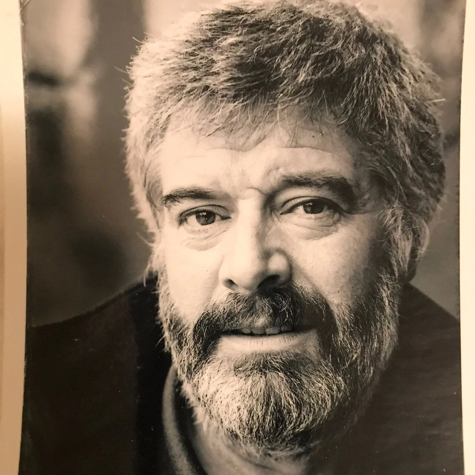 Black and white magazine cover portrait of a middle-aged man with a full beard and tousled hair.