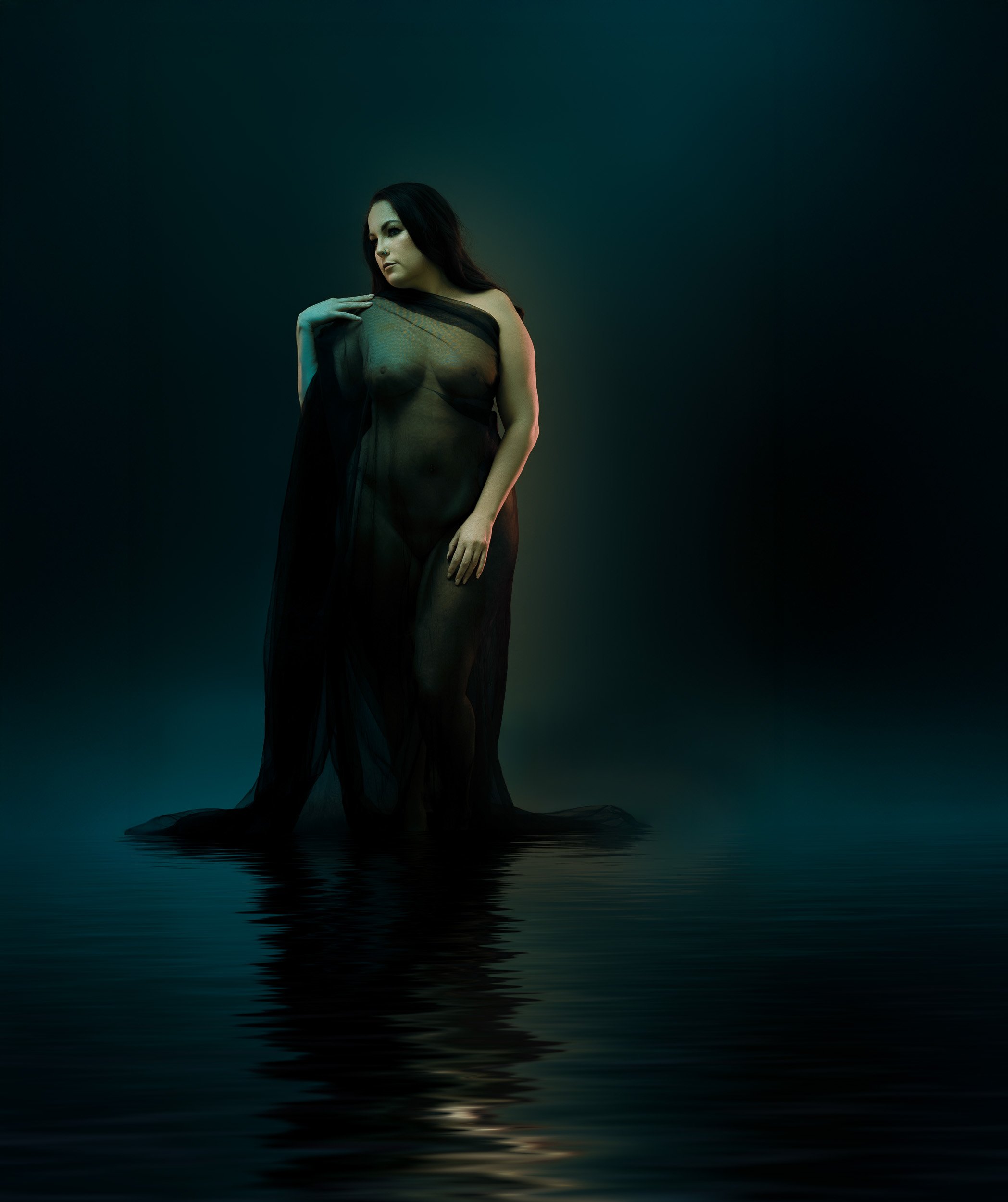 Fine art boudoir portrait by Amanda Chantee in Vancouver, WA, featuring a woman in flowing dark fabric under dramatic teal studio lighting.
