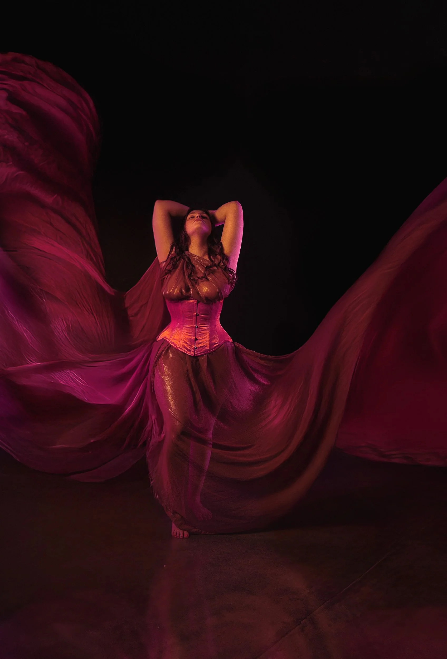 Fine art boudoir portrait by Amanda Chantee featuring a woman in red lingerie surrounded by flowing red fabric and dramatic studio lighting.