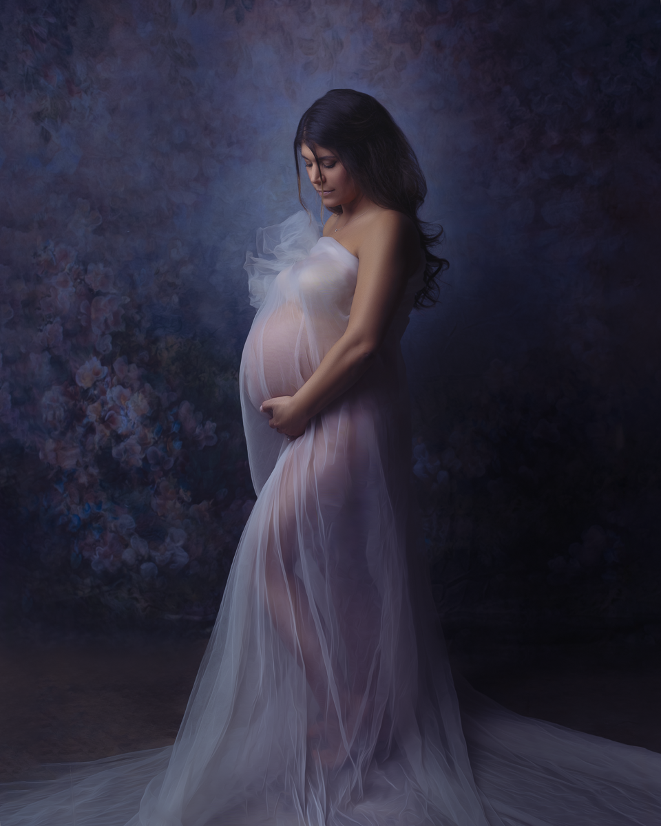 Vancouver WA fine art maternity portrait of a pregnant woman wrapped in flowing fabric with dramatic painterly lighting, creating an oil painting inspired look by Amanda Chantee Photography.