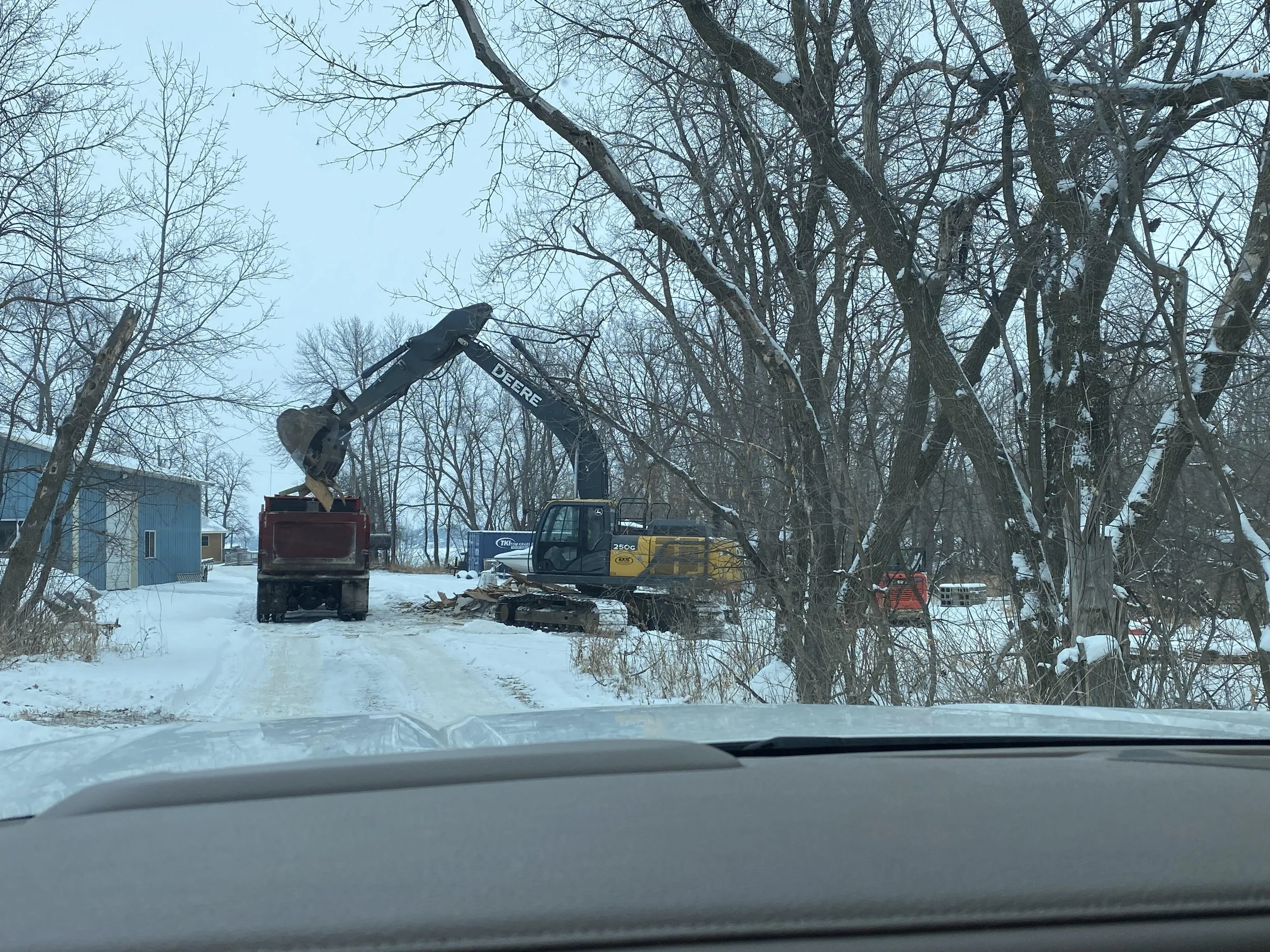 Excavator loads remnants of building into dump truck on Minnesota Lakeside Resort