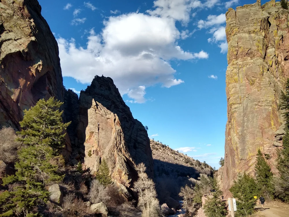 Tall sandstone walls in Eldorado Canyon State Park under a blue sky