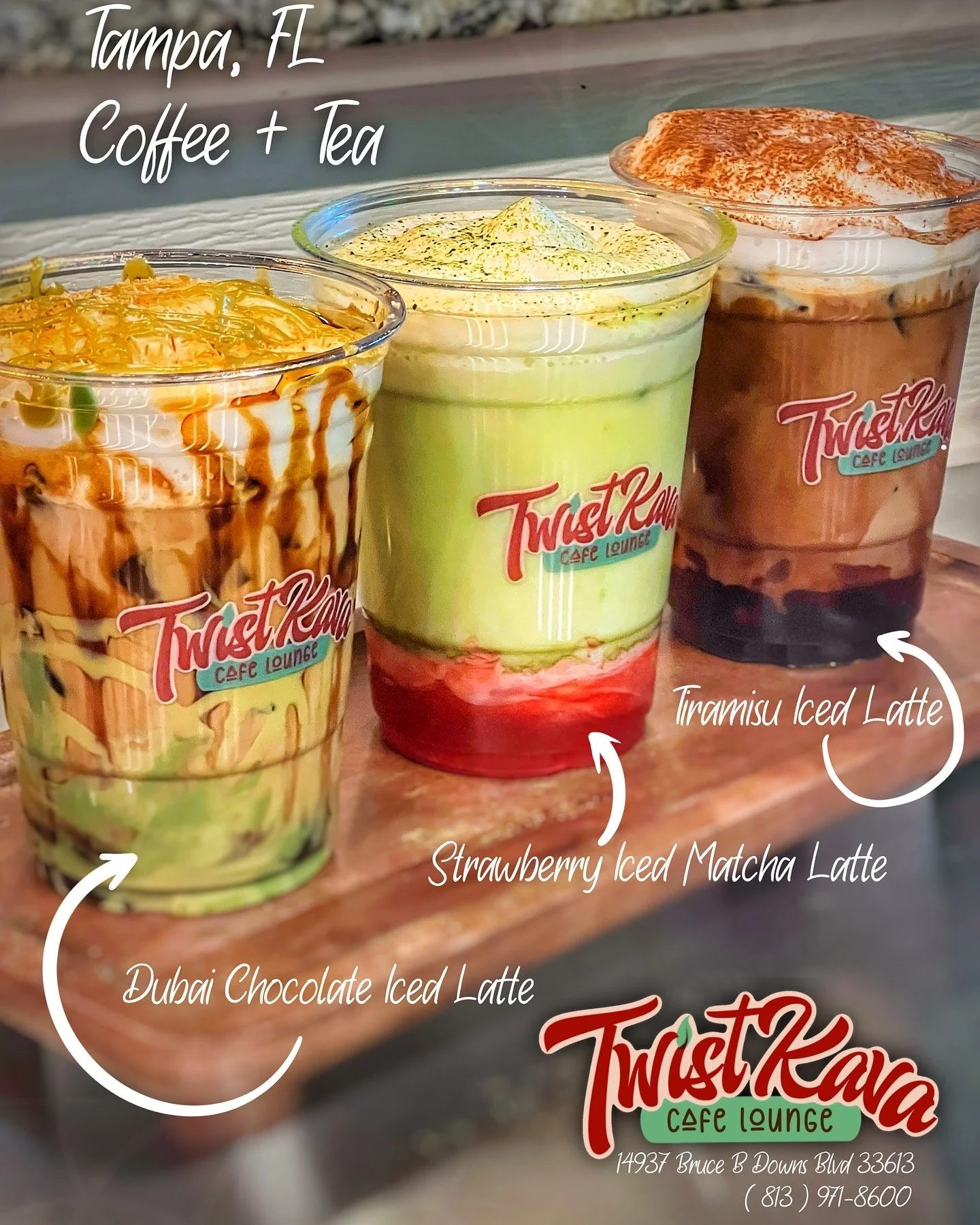 Three iced coffee drinks on a wooden board at Twist Karina Cafe Lounge in Tampa, FL. From left to right: Dubai Chocolate Iced Latte, Strawberry Iced Matcha Latte, Tiramisu Iced Latte. Each drink has a different color and toppings.