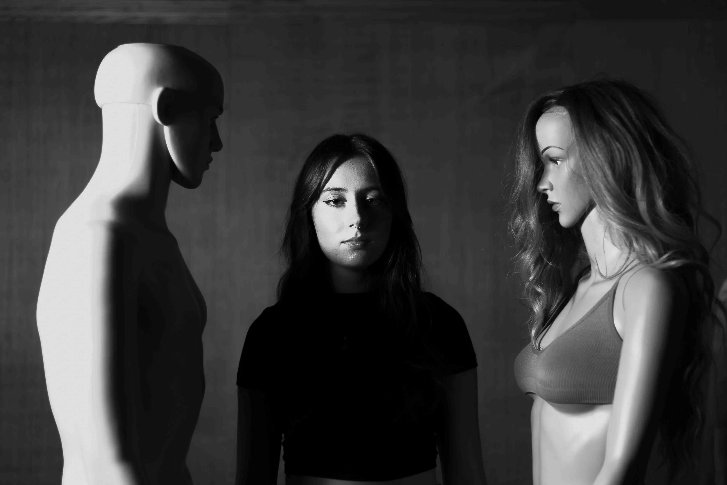 Black and white editorial portrait of mannequins posed seriously in a studio setting