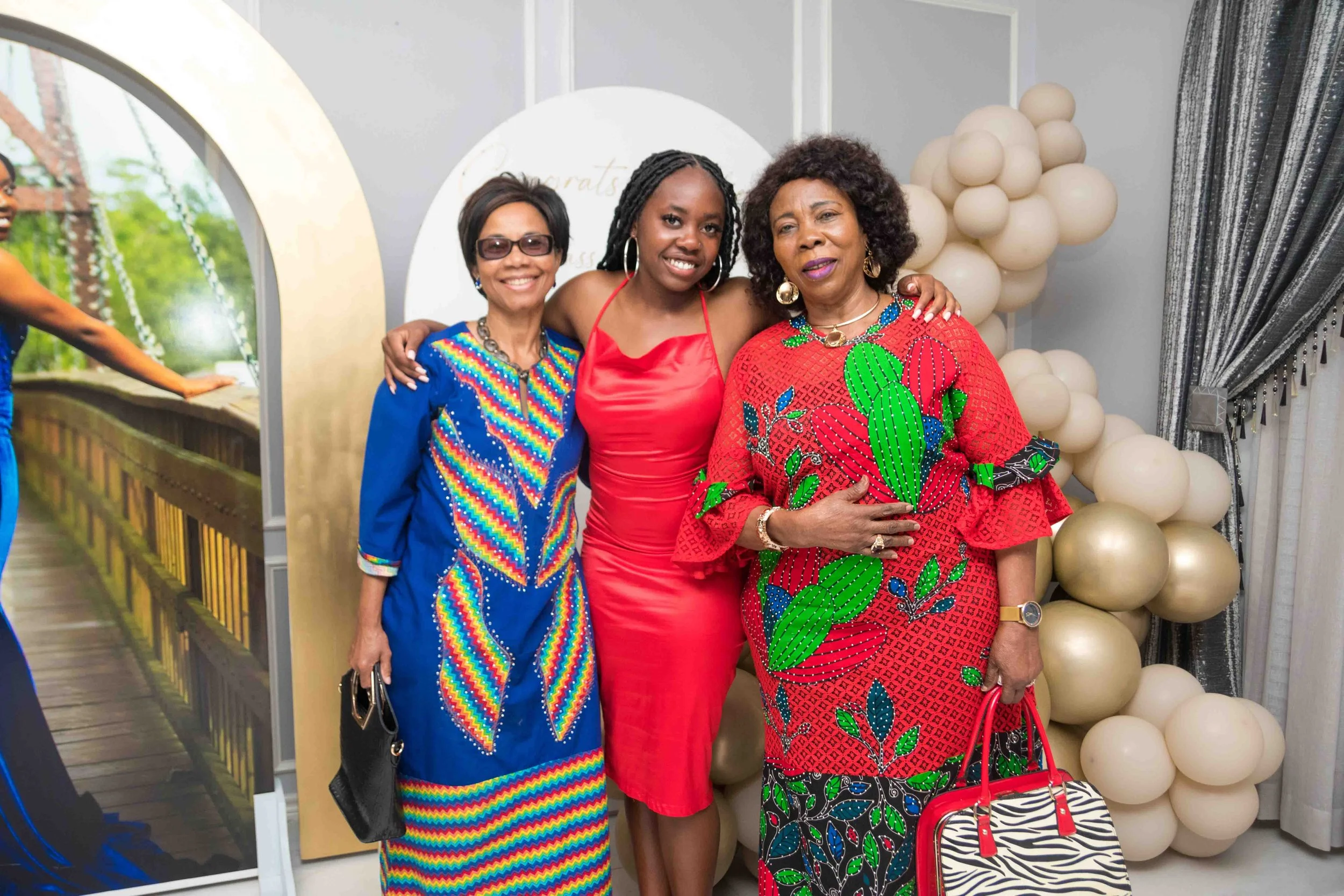 Houston birthday home party photography by Lev's Photography featuring three women standing together indoors in colorful dresses, with balloons in the background, capturing joyful and candid moments at a private house celebration.