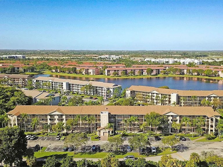 Aerial view of residential apartments with a lake and greenery