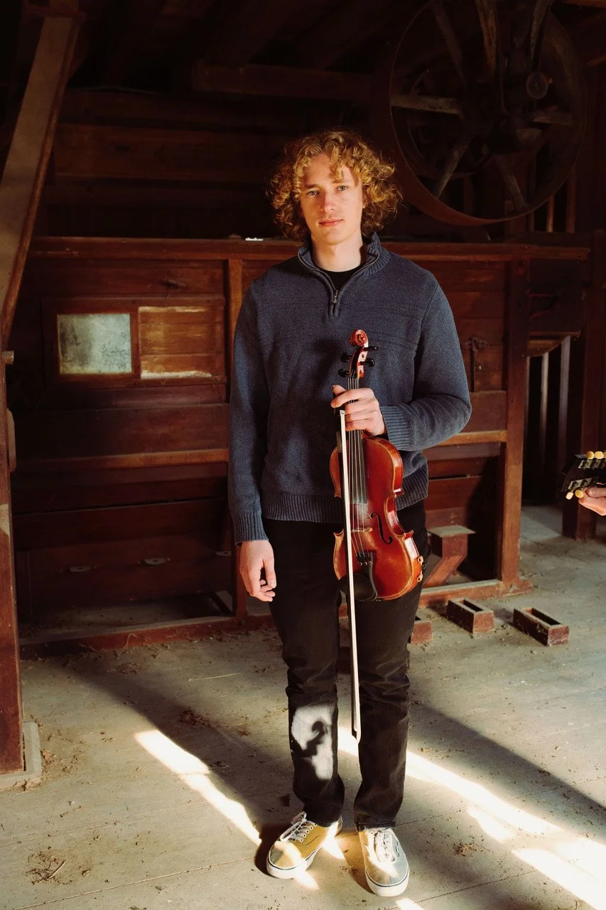 Huck Tritsch standing with fiddle in hand